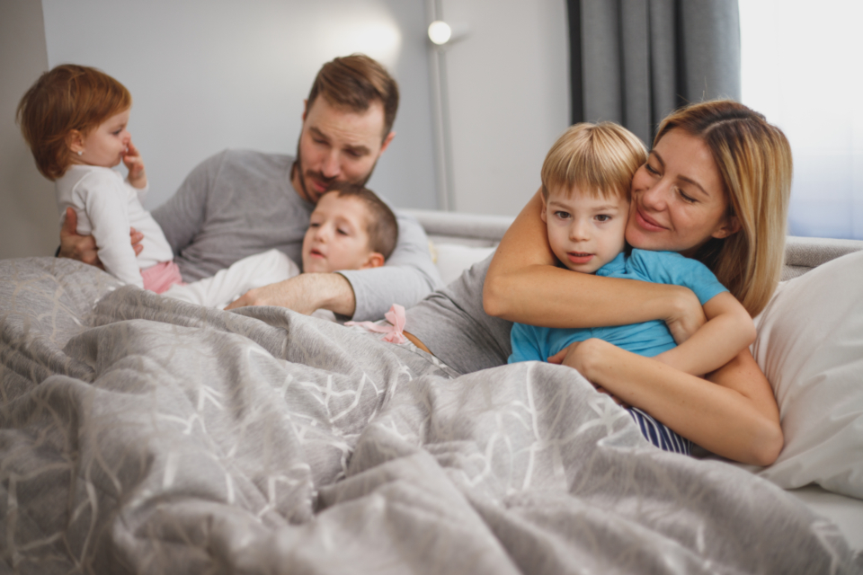 Two parents and three children sitting together at home